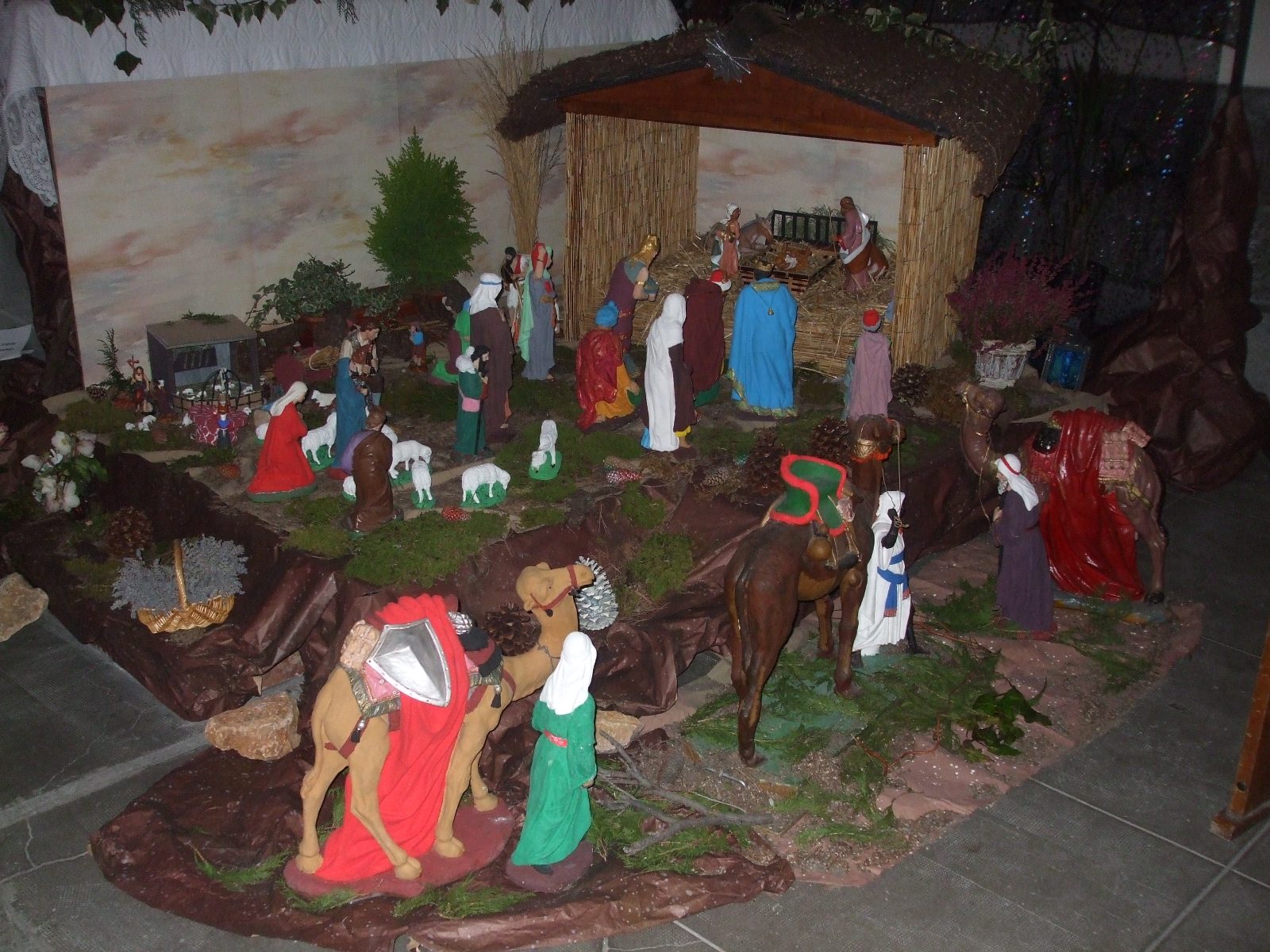 A large nativity scene in the church of Le Teil, France, lit in the half-light of the nave
