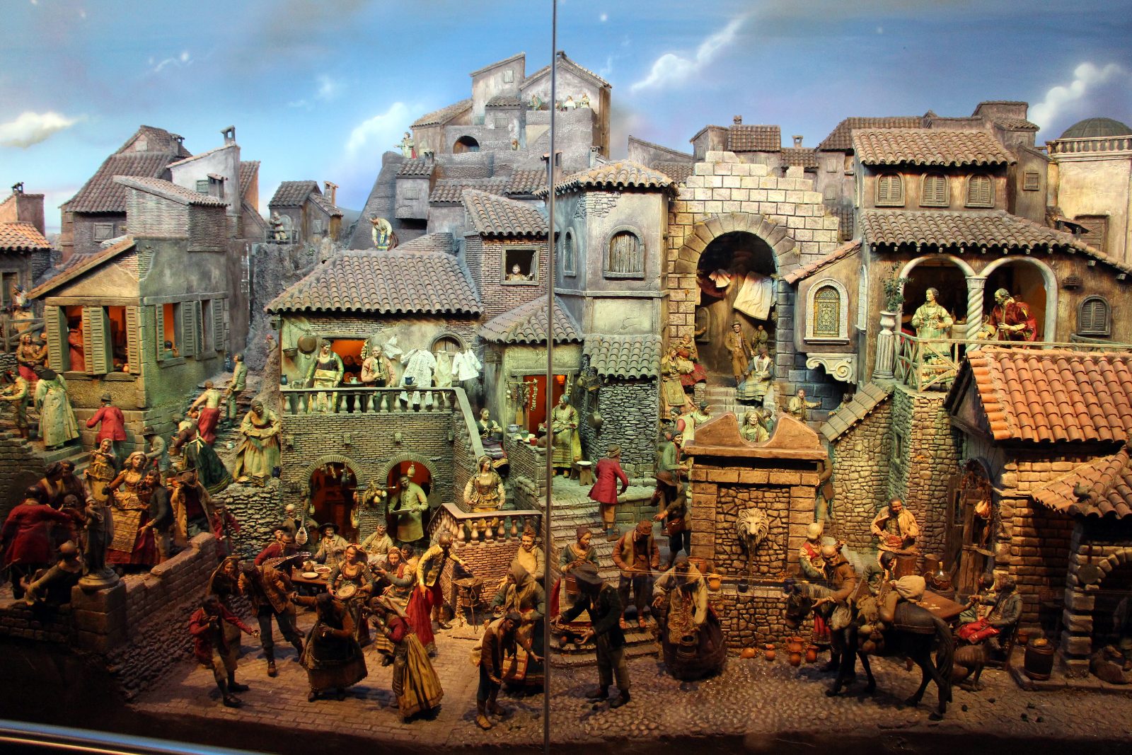 An 18th-century Neapolitan nativity: ancient ruins, a village in tiers and figures dressed in fabric